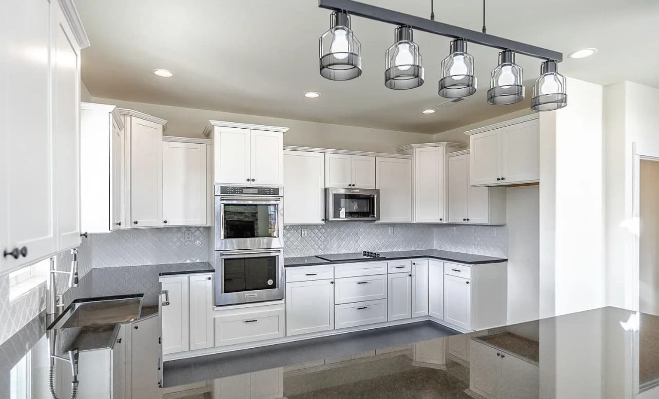 White shaker kitchen with arabesque tile backsplash and double wall oven