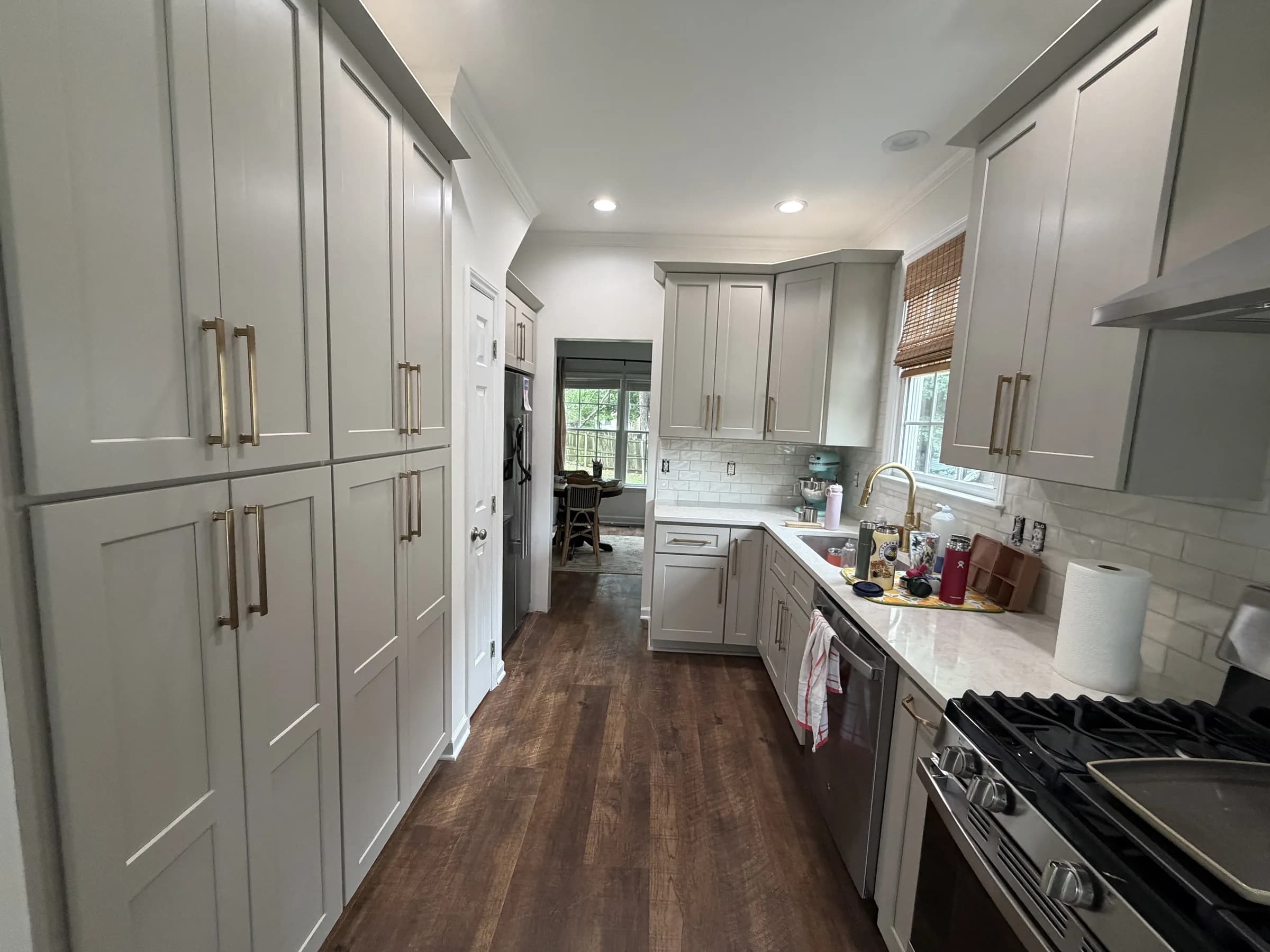Apex kitchen remodel with sand-colored Shaker cabinets, quartz countertops, subway tile and pantry cabinets
